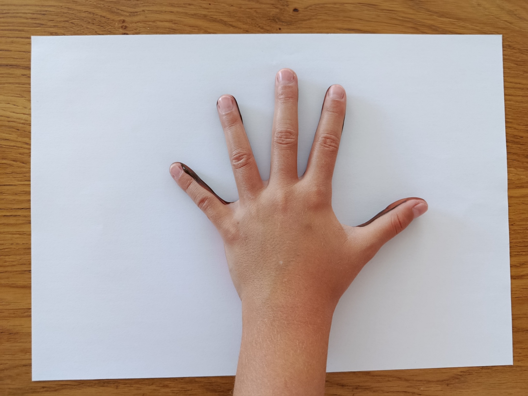 La mà pintada pressiona un full blanc.